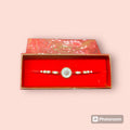 Precious stone rakhi presented in a red velvet box